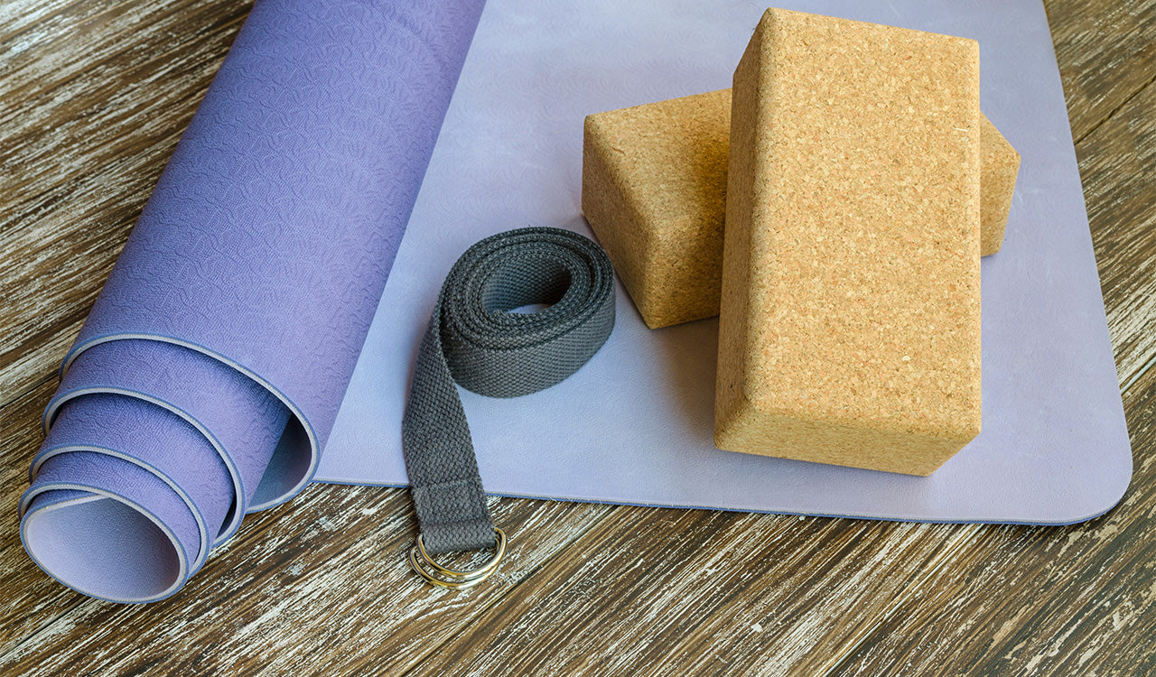 Set d’accessoires de Pilates écoresponsables posés au sol, incarnant la simplicité et le minimalisme conscient.